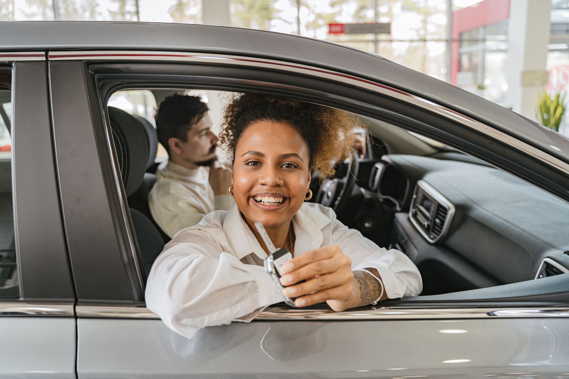 Cliente feliz com a chave do carro novo